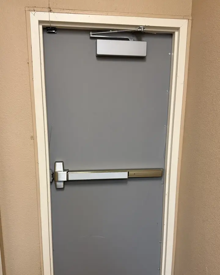 After: new gray steel back door with panic bar and door closer at a TitleMax store in Dallas